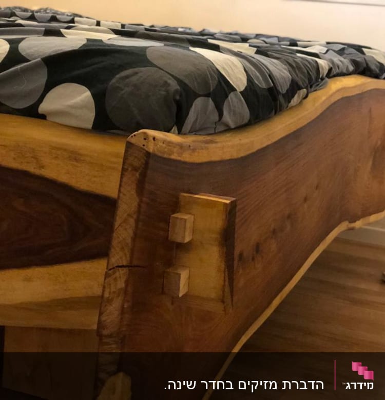 מיטה מעץ עם מצעים בצבעים כהים